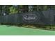 A tennis court with a black net fence surrounding the court. The Hadfield community name is on the fence at 235 Foxley Way, Roswell, GA 30075