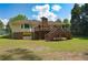 Back of house with multilevel wooden deck, green lawn and a drive-in garage under the home at 4137 Wellington Hills Ln, Snellville, GA 30039