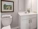 Well-lit bathroom showcasing white cabinetry and a framed landscape painting above the toilet at 5615 Hislop Ln # 82, Mableton, GA 30126