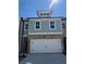 Charming exterior elevation of two-story townhome with brick and board and batten at 5615 Hislop Ln # 82, Mableton, GA 30126