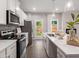 Open kitchen featuring stainless appliances, white cabinetry, island and an exterior access door at 5615 Hislop Ln # 82, Mableton, GA 30126