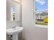 Bright powder room with a pedestal sink and a view of the neighborhood at 5615 Hislop Ln # 82, Mableton, GA 30126