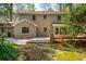 Rear view of the home showcasing a wooden deck, patio, and a well-maintained backyard with lush landscaping at 6795 Brandon Mill Rd, Atlanta, GA 30328