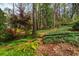 Serene backyard featuring mature trees, landscaping, and a peaceful path at 6795 Brandon Mill Rd, Atlanta, GA 30328