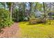 A lush, green yard with flowering plants and trees surrounding a two-story home, creating a serene outdoor space at 6795 Brandon Mill Rd, Atlanta, GA 30328