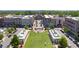 A vibrant community scene is showcased, featuring a green space with people enjoying outdoor activities amidst shops and tree-lined streets at 8675 Hope Vine, Roswell, GA 30076