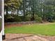 Expansive backyard with a stone retaining wall, lush greenery, and privacy at 8675 Hope Vine, Roswell, GA 30076