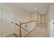 Upstairs hallway with white doors, neutral paint, carpeted floors and a wooden railing at 8675 Hope Vine, Roswell, GA 30076