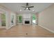 Bright living room featuring a fireplace, wood floors, neutral walls, ceiling fan, and lots of natural light at 8675 Hope Vine, Roswell, GA 30076