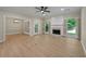 Bright living room featuring a fireplace, wood floors, neutral walls, ceiling fan, and lots of natural light at 8675 Hope Vine, Roswell, GA 30076