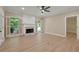 Bright living room featuring a fireplace, wood floors, neutral walls, ceiling fan, and lots of natural light at 8675 Hope Vine, Roswell, GA 30076