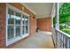 Covered front porch with white railing and brick columns at 8675 Hope Vine, Roswell, GA 30076