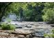 Scenic view of waterfalls flowing into a river, surrounded by lush greenery at 8675 Hope Vine, Roswell, GA 30076