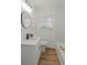 Inviting bathroom featuring wood-look floors, bright lighting, and a sleek round mirror, for a calming atmosphere at 2378 Green Forrest Dr, Decatur, GA 30032