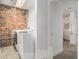 Clean laundry room with washer, dryer, exposed brick, and bright lighting at 204 Walker Sw St # 319, Atlanta, GA 30313