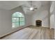 Bright living room with vaulted ceiling, fireplace, large window, and sleek wood-look flooring at 26 Nottingham Nw Dr, Cartersville, GA 30121