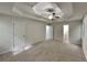 Large main bedroom showcasing tray ceiling, ceiling fan, carpet, and ensuite access at 26 Nottingham Nw Dr, Cartersville, GA 30121