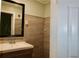 Remodeled bathroom featuring a wood vanity, new sink, an updated mirror and modern tile flooring and walls at 3967 Norman Rd, Stone Mountain, GA 30083