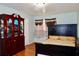 Comfortable bedroom with hardwood floors, a queen bed, a dresser, and a lovely red armoire for storage at 3967 Norman Rd, Stone Mountain, GA 30083