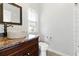 Bathroom with stone sink, granite counters, wood cabinets and white tiles at 4011 Charrwood Trce, Marietta, GA 30062