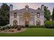 Stately white home featuring a manicured lawn, beautiful landscaping, a symmetrical facade, and black-framed windows at 4011 Charrwood Trce, Marietta, GA 30062