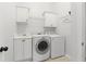 Well-lit laundry room with white washer, dryer, cabinets, and utility sink at 4011 Charrwood Trce, Marietta, GA 30062
