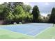 Community tennis court surrounded by trees and equipped with benches at 4011 Charrwood Trce, Marietta, GA 30062