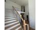 Modern staircase with wooden steps, black metal railings, and abundant natural light from nearby windows at 4107 Danforth Sw Rd, Atlanta, GA 30331