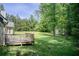 Expansive backyard featuring a wooden deck, lush lawn, mature trees, and storage shed at 414 Pamela Ct, Mcdonough, GA 30252