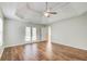 Spacious bedroom featuring tray ceilings, wood floors, and natural light from the windows at 414 Pamela Ct, Mcdonough, GA 30252