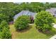 Aerial view of a two-story home showcasing mature trees, a well-manicured lawn, and a peaceful, wooded setting at 1213 Fairwinds Dr, Loganville, GA 30052
