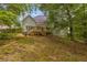Green backyard features a wood deck with stairs descending into yard with lush green lawn at 1213 Fairwinds Dr, Loganville, GA 30052