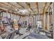 Unfinished basement, features exposed beams and workout area with free weights and stationary bike at 1213 Fairwinds Dr, Loganville, GA 30052