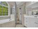 Luxurious bathroom with tub, glass shower, double sink vanity, and natural light at 1213 Fairwinds Dr, Loganville, GA 30052