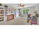 Bedroom featuring built-in bookcases, desk, ceiling fan and natural light from a window at 1213 Fairwinds Dr, Loganville, GA 30052