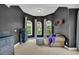 A well-lit bedroom featuring a sitting area, bay windows, and neutral carpet at 1213 Fairwinds Dr, Loganville, GA 30052