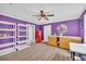 Bedroom featuring vinyl flooring, purple painted walls, a ceiling fan, and a red mini fridge at 1213 Fairwinds Dr, Loganville, GA 30052