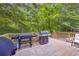 Outdoor wooden deck featuring a grilling area with multiple grills and a serene wooded backdrop at 1213 Fairwinds Dr, Loganville, GA 30052