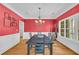 Elegant dining room featuring bold red walls, white wainscoting, hardwood floors, and a chandelier at 1213 Fairwinds Dr, Loganville, GA 30052