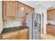 A kitchen featuring granite countertops, stainless steel refrigerator, and wooden cabinets at 1213 Fairwinds Dr, Loganville, GA 30052