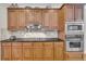 A well-appointed kitchen with stainless steel appliances, wooden cabinets, and tile backsplash at 1213 Fairwinds Dr, Loganville, GA 30052
