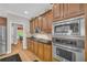 Kitchen featuring stainless steel appliances, tile backsplash, wooden cabinets, and hardwood floors at 1213 Fairwinds Dr, Loganville, GA 30052