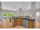 Kitchen featuring granite countertops, wooden cabinets, stainless steel dishwasher, and hardwood floors at 1213 Fairwinds Dr, Loganville, GA 30052
