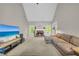 Bright living room featuring a brick fireplace, vaulted ceiling, and a large TV at 1213 Fairwinds Dr, Loganville, GA 30052
