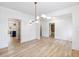 Bright dining room with white wainscoting, hardwood floors and unique lighting fixture at 4377 Hosch Reserve Dr, Buford, GA 30519