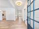 Elegant entryway features hardwood floors, wainscoting, modern light fixture and a blue front door at 4377 Hosch Reserve Ct, Buford, GA 30519