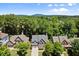 Aerial view of a brick home surrounded by lush greenery, showcasing its location and neighborhood at 580 Washington Way, Cumming, GA 30040