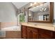 This primary bathroom features a soaking tub, large mirrors, and abundant cabinet space at 580 Washington Way, Cumming, GA 30040