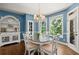 Bright breakfast nook features a chandelier, and a round dining table next to large windows at 580 Washington Way, Cumming, GA 30040