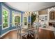 Sunlit breakfast nook has a round table, modern chandelier, and view to the living room with fireplace at 580 Washington Way, Cumming, GA 30040